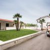 Marciapiede in giardino con golf cart e case bianche.