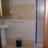 Bagno con lavabo, doccia e cestino.