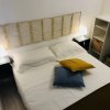 Letto matrimoniale con cuscini colorati e lampade sui comodini.