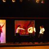 Spettacolo sul palco con tre persone che ballano.