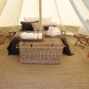 Interno di tenda con letto e cesta di vimini.