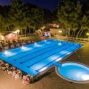 Piscina illuminata di notte con bar all'aperto.