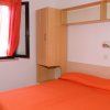 Camera da letto con letto matrimoniale e tenda arancione.