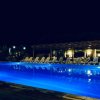 Piscina illuminata di notte con lettini attorno.