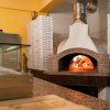 Forno a legna per pizza con scatole accatastate.